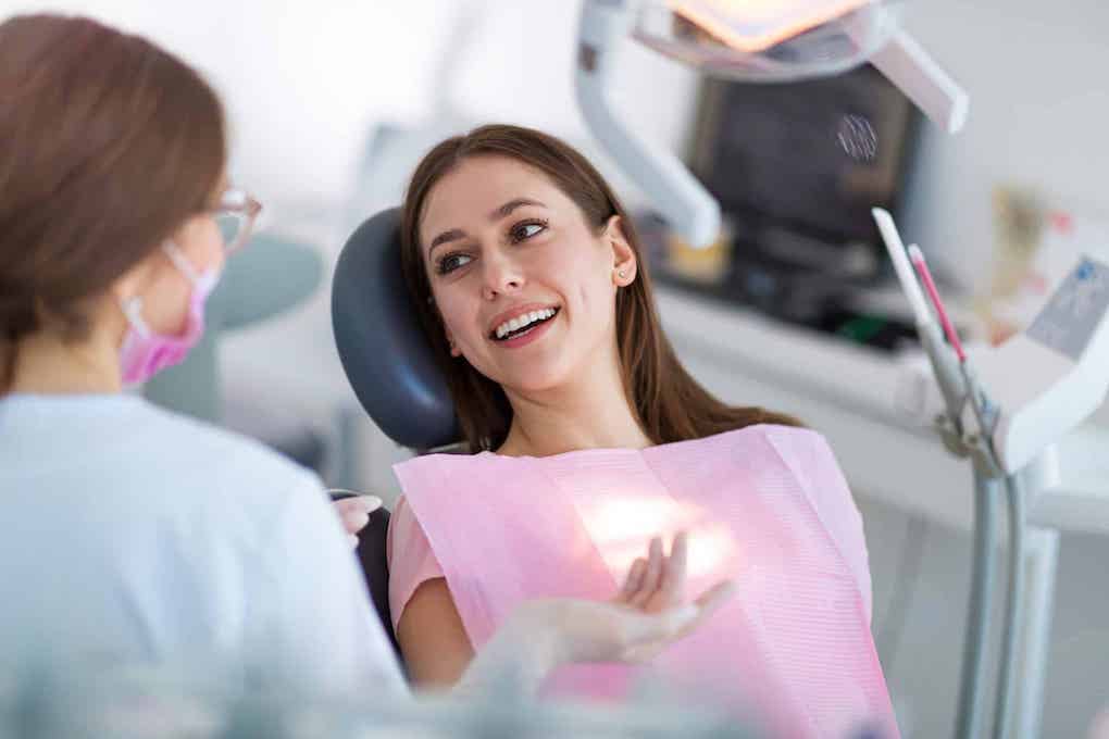 dentist explaining to patient in chair what is the best way to whiten teeth