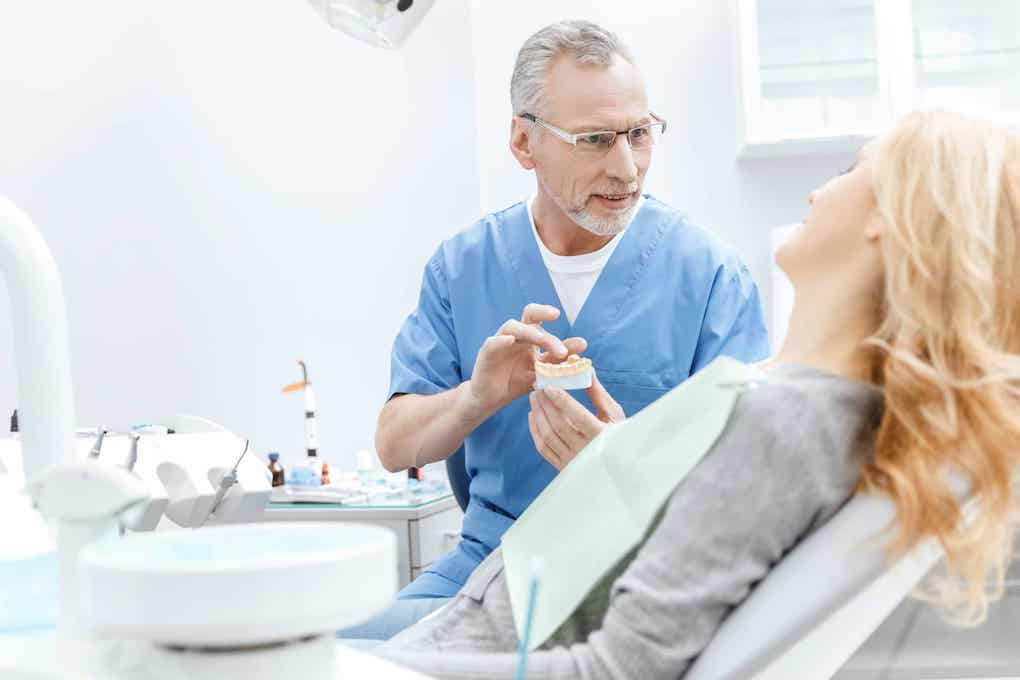 dentist explaining the benefits of laser dentistry to woman in chair